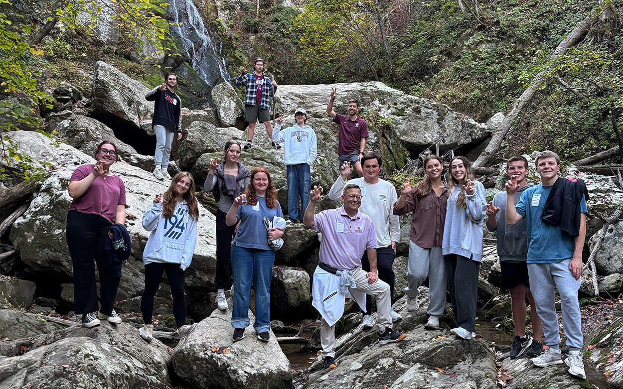 Students posing for photo on rocks