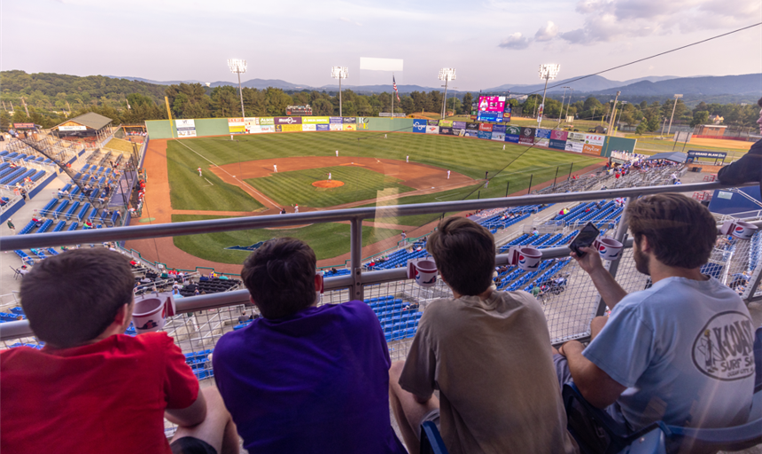 four students overlooking the baseball stadium