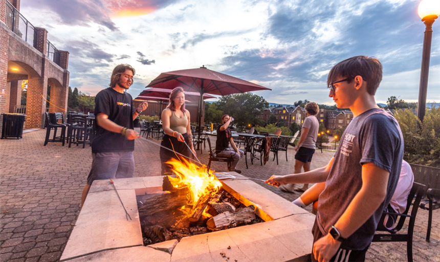 four students making s'mores on the Sutton Terrace