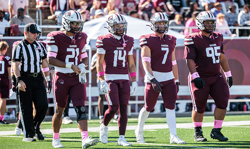 referee and four Roanoke College football players walking