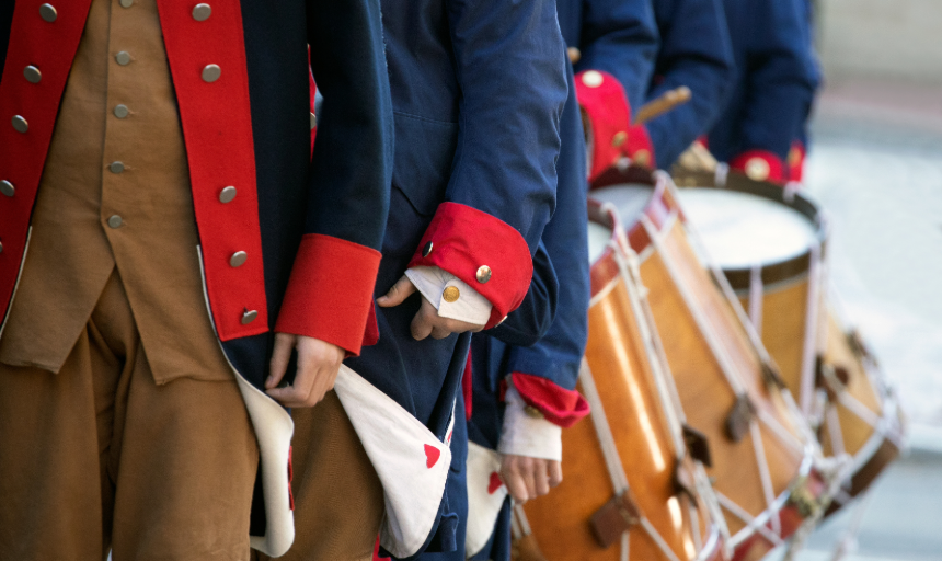 Closeup image of reenactors wearing American revolutionary uniforms and carrying drums 