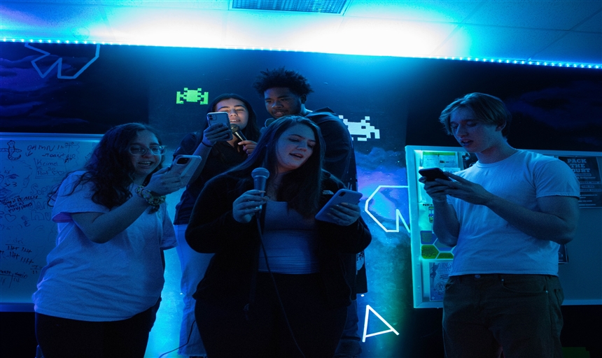 students in the gameroom singing together 