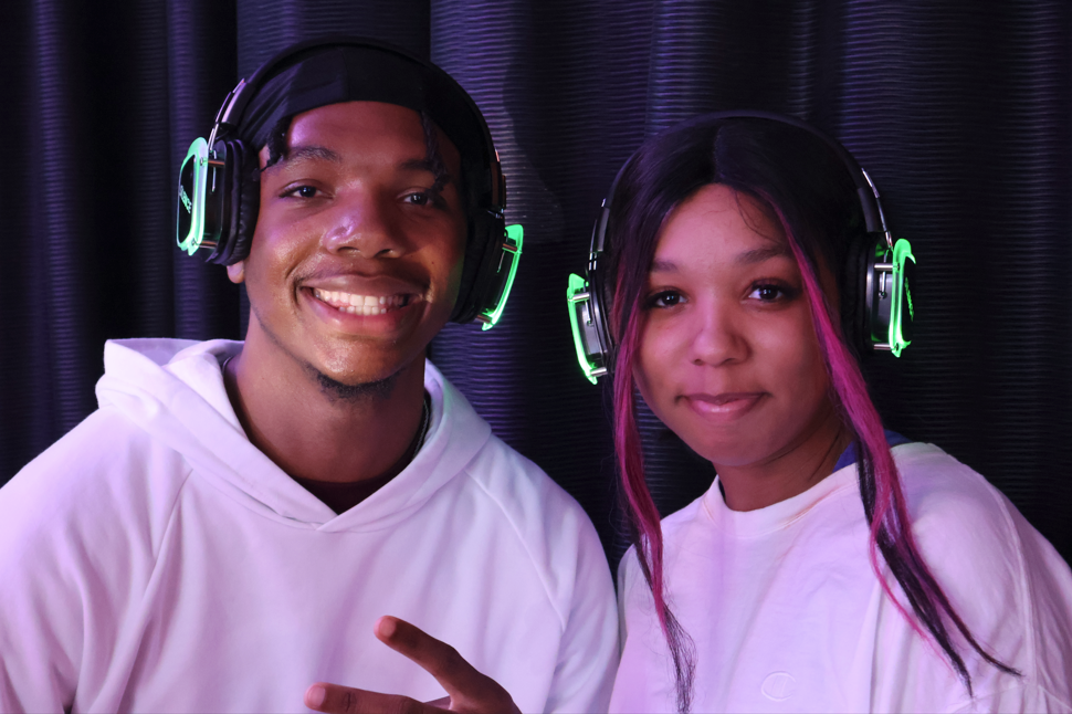 Two students wearing silent disco headphones posing for the camera