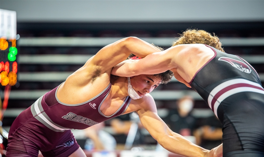 Two wrestlers grappling in a match