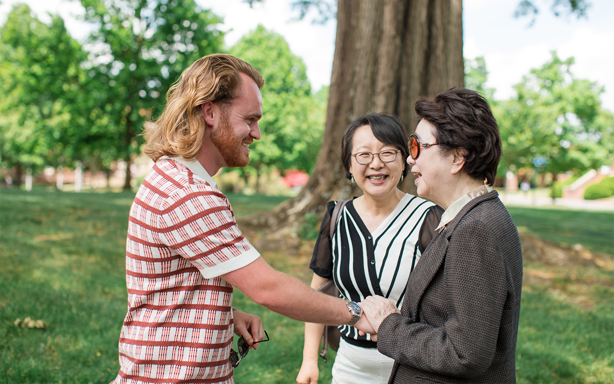 Lewis Edwards shaking hands with Dr. Kim Soo-oak while Stella Xu looks on