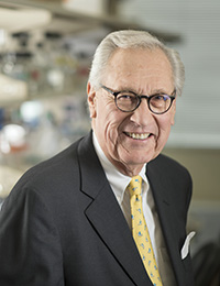headshot of an older man in a dark suit