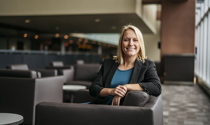 Portrait of smiling young woman seated in a lounge area.