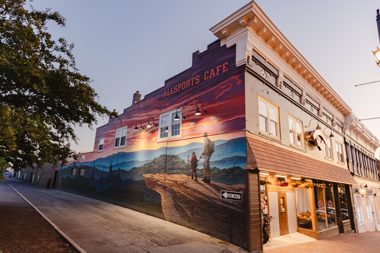 Mural on the side of a brick building that depicts a man and child pausing on top of McAfee Knob to look over the Blue Ridge Mountains.