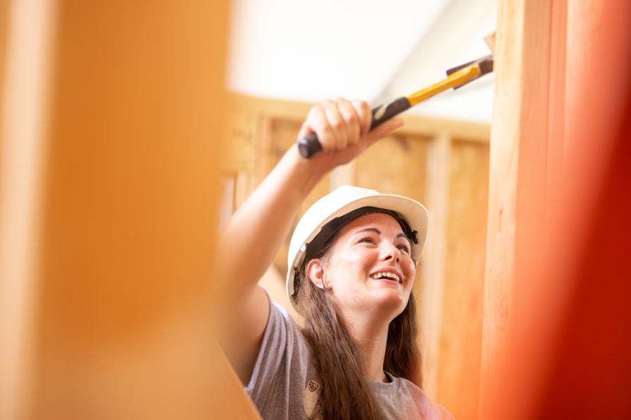 student with a hammer working on R House
